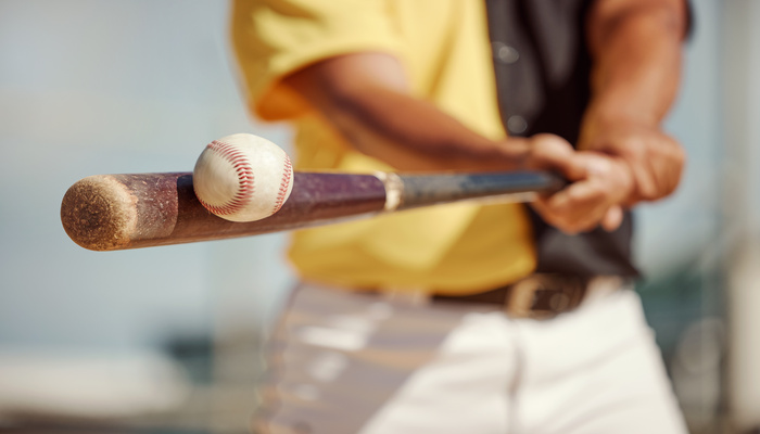 Home 1 Close-up of a baseball approaching a bat held by a player, highlighting hand-eye coordination during a swing.